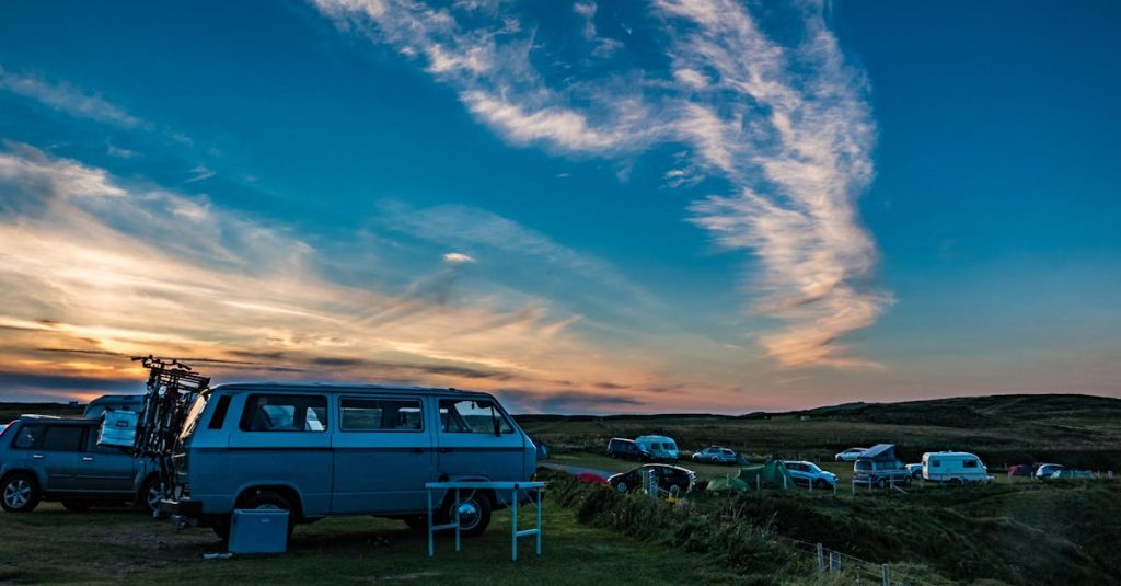 A scenic sunset view of Volkswagen campervans parked in Durness, Scotland.
